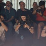 Group of photographers attentively capturing moments in a workshop setting indoors.