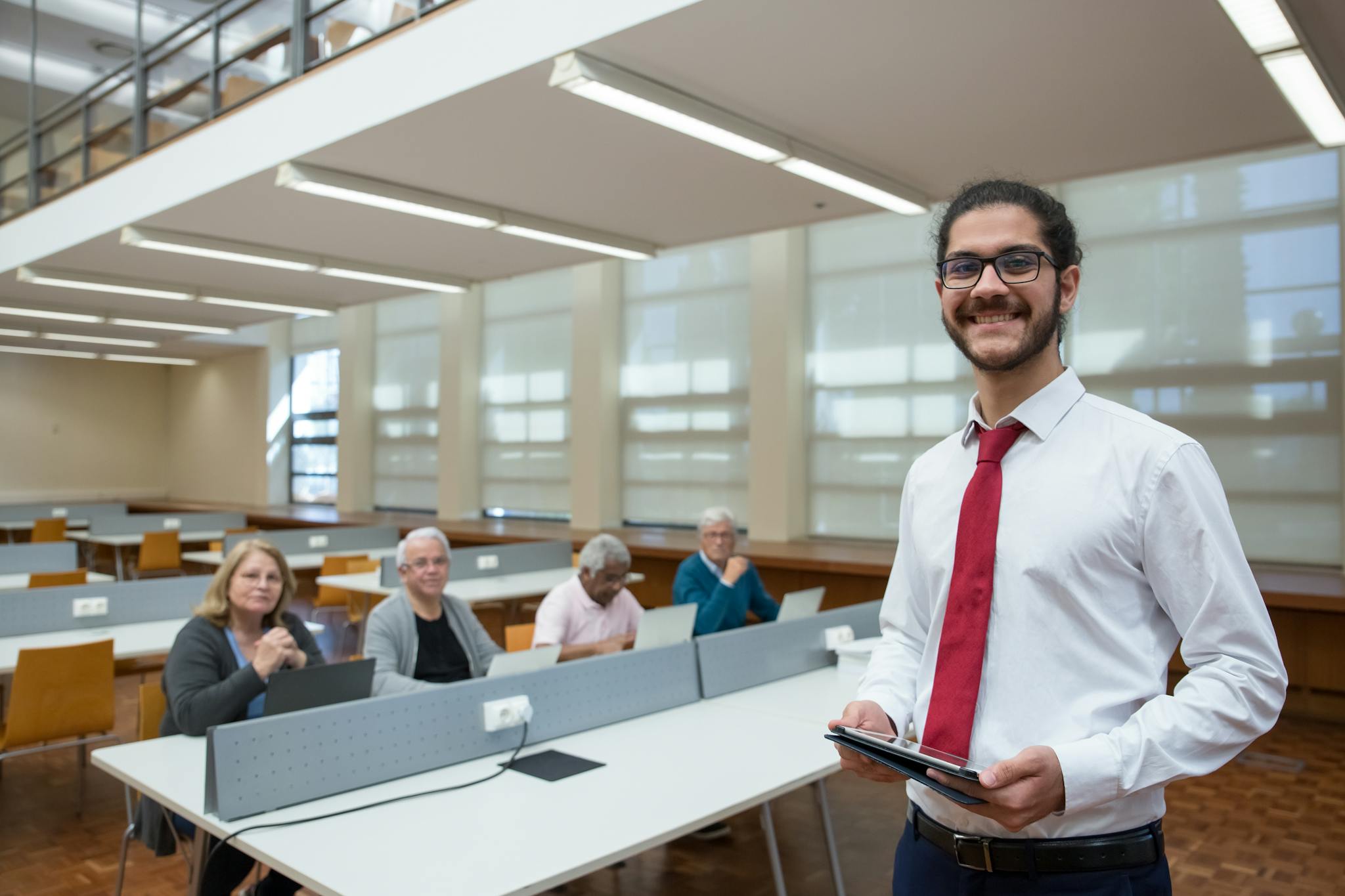 Young professional leading a training session in a modern office with senior adults.